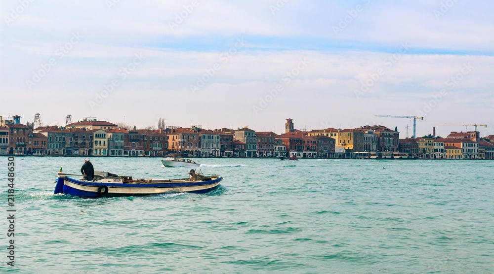 Fisherman boat in Venice Italy background