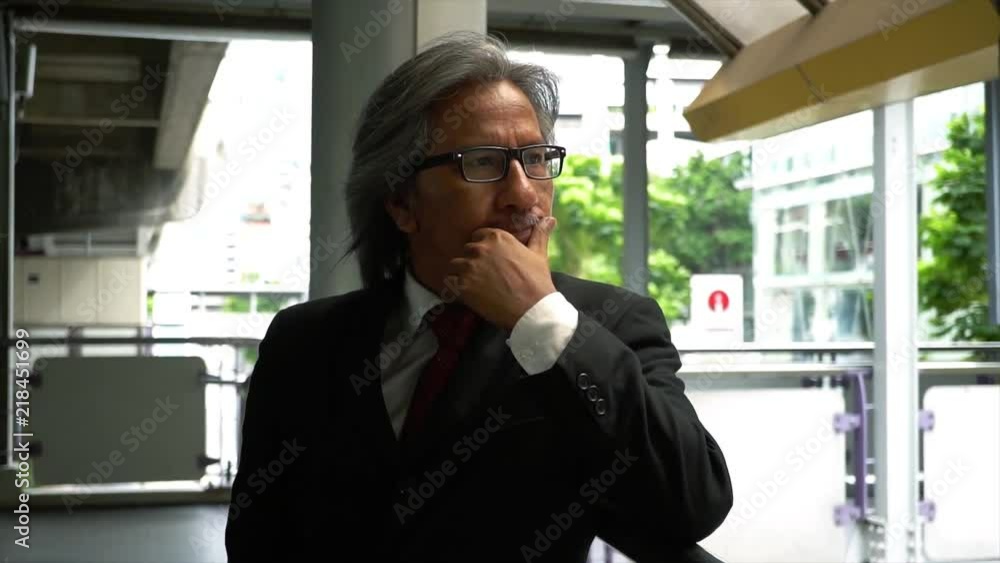 Senior mature business man with grey hair thinking at the train station Senior mature business man with grey hair thinking at the train station