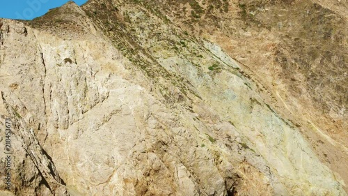 A large hawk surveys the land below, before flying back over the other side of a mountain ridge at McClures Beach, CA. photo