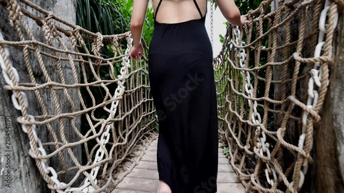 Lifestyle footage of Asian Chinese woman walking across rope bridge 