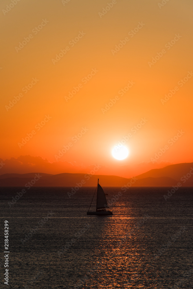 Lonely yacht at sea during sunrise in the early morning.