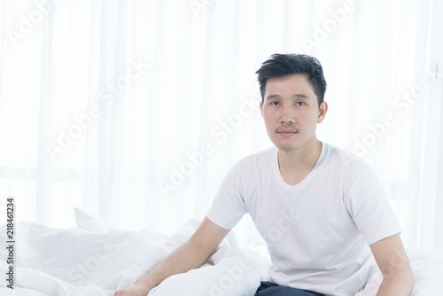 Asian man has wake up with lazying on bed in the morning.