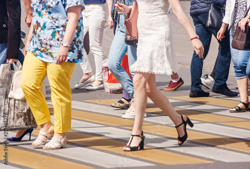 legs of pedestrians in a crosswalk on summer day
