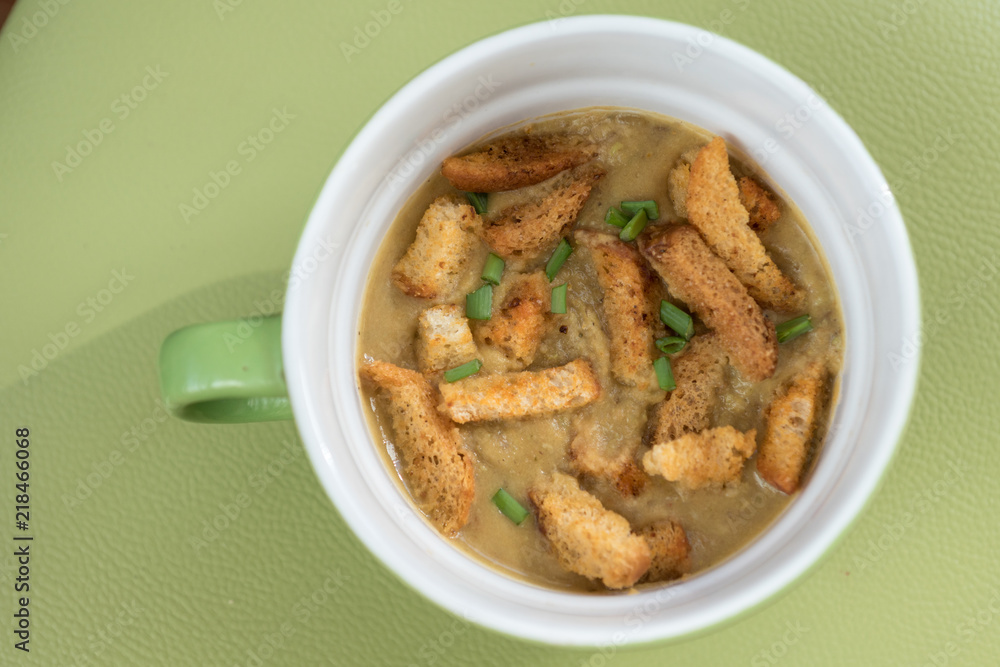 soup Cup with vegetable soup with crackers on green background soup Cup with vegetable soup with crackers on green background