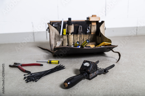 Box with electrician tools on leather background photo