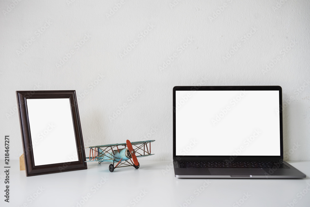 Workspace with blank screen laptop and copy space on white desk.