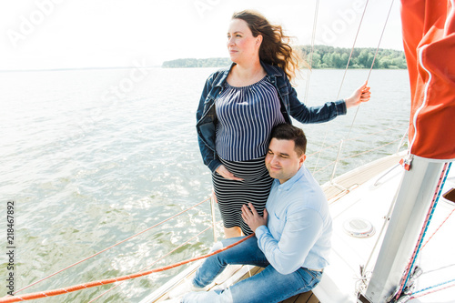 Pregnant woman with husband on yacht. Happy pregnancy concept. Young family on vacation. © beatleoff