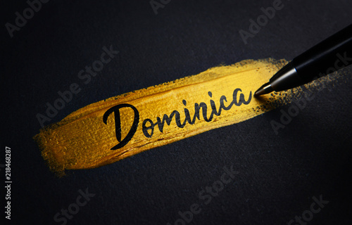 Dominica Handwriting Text on Golden Paint Brush Stroke