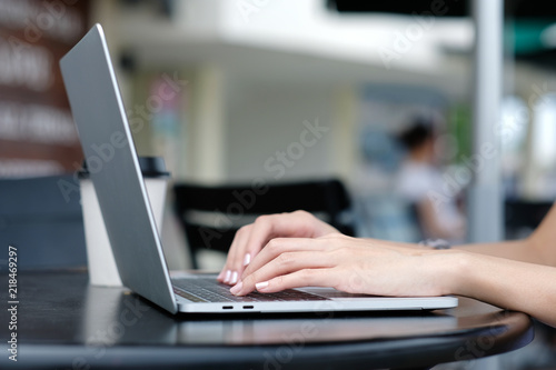 Woman hand using laptop computer at outdoors background, people and technology, lifestyles
