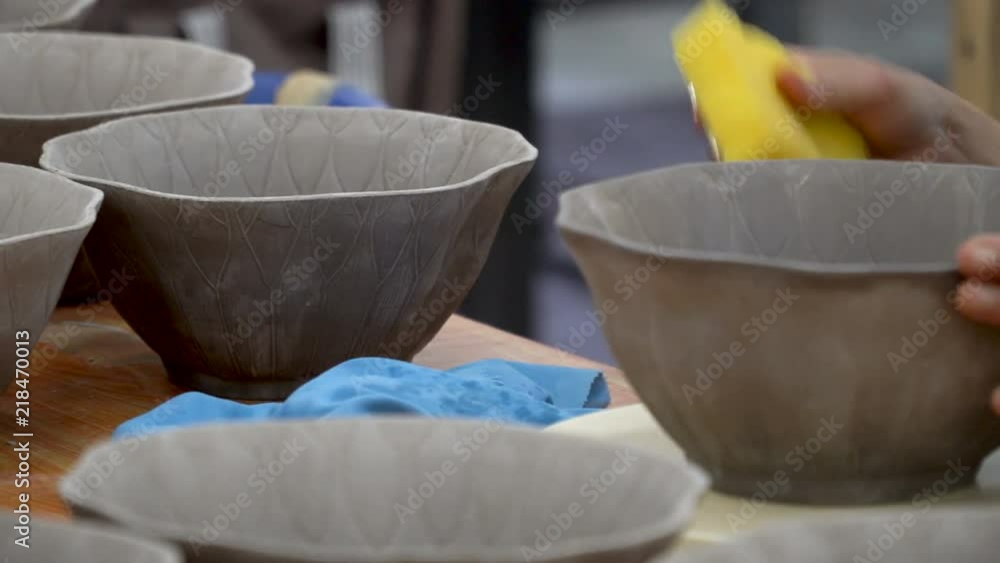 traditional pottery making, close up of potter's hands shaping a bowl on the spinning by clay traditional pottery making, close up of potter's hands shaping a bowl on the spinning by clay