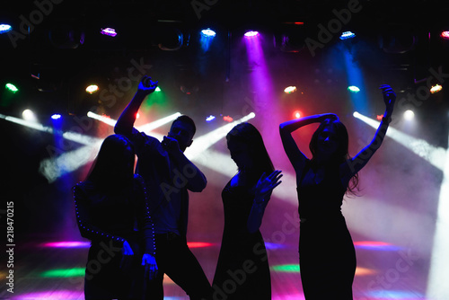 Młodzi szczęśliwi ludzie tańczą w klubie. Koncepcja życia nocnego i dyskoteki.