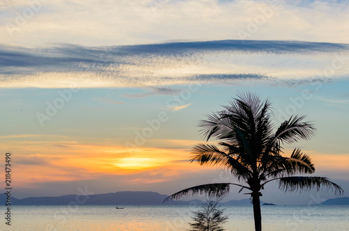 Sunset on tropical beach and coconut palm tree and fisherman boat