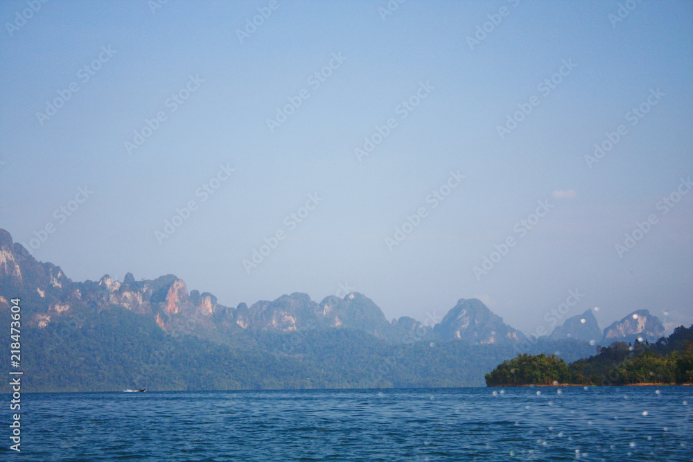 Landscape of Dam with Mountain and river near forest hills in Blue sky at Ratchaprapha Dam at Khao Sok National Park, Surat Thani Province, Thailand.