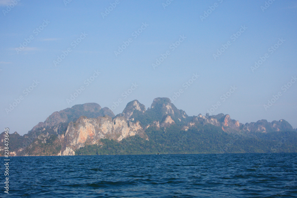 Landscape of Dam with Mountain and river near forest hills in Blue sky at Ratchaprapha Dam at Khao Sok National Park, Surat Thani Province, Thailand. Landscape of Dam with Mountain and river near forest hills in Blue sky at Ratchaprapha Dam at Khao Sok National Park, Surat Thani Province, Thailand.