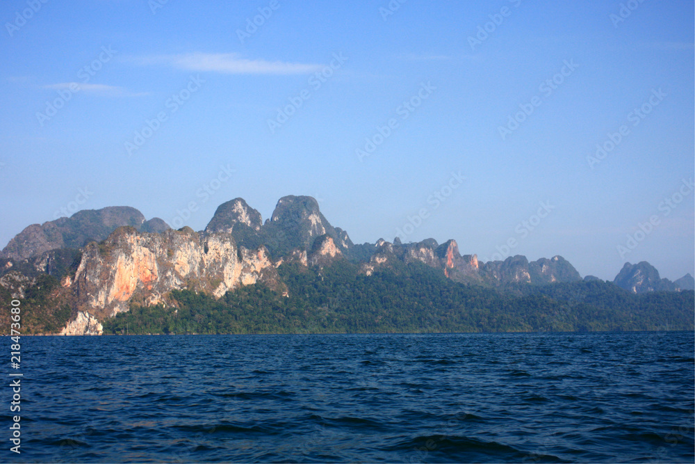 Landscape of Dam with Mountain and river near forest hills in Blue sky at Ratchaprapha Dam at Khao Sok National Park, Surat Thani Province, Thailand.