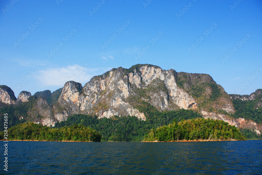 Landscape of Dam with Mountain and river near forest hills in Blue sky at Ratchaprapha Dam at Khao Sok National Park, Surat Thani Province, Thailand. Landscape of Dam with Mountain and river near forest hills in Blue sky at Ratchaprapha Dam at Khao Sok National Park, Surat Thani Province, Thailand.