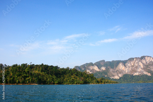 Landscape of Dam with Mountain and river near forest hills in Blue sky at Ratchaprapha Dam at Khao Sok National Park, Surat Thani Province, Thailand. © cocorattanakorn