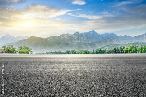 Fotografie Empty asphalt highway and green mountain nature landscape at sunset