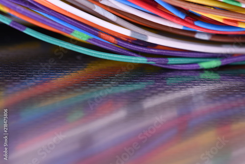 Metal surface with reflection of colorful electrical wires