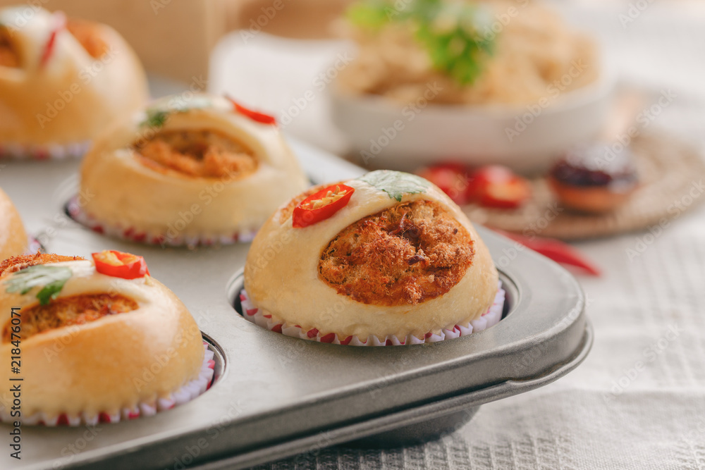 Homemade cup of soft and sticky bun with dried shredded pork or pork floss and shrimp roasted chili paste in muffin tray on wood table. Thai style delicious bread with sweet and spicy taste for snack. Homemade cup of soft and sticky bun with dried shredded pork or pork floss and shrimp roasted chili paste in muffin tray on wood table. Thai style delicious bread with sweet and spicy taste for snack.