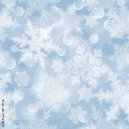 Christmas seamless pattern with white blurred snowflakes, glare and sparkles on light blue background