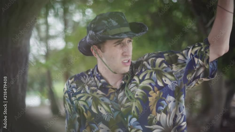 Young Male explorer in Tilly Hat scans the horizon in tropical setting Young Male explorer in Tilly Hat scans the horizon in tropical setting