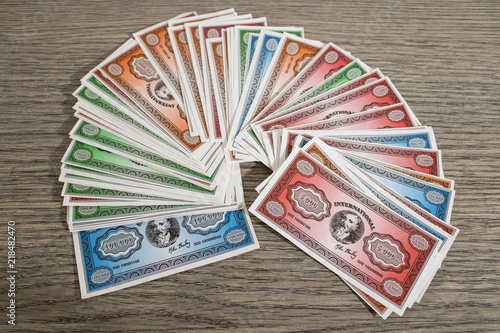 Colored fake banknotes on a wood table