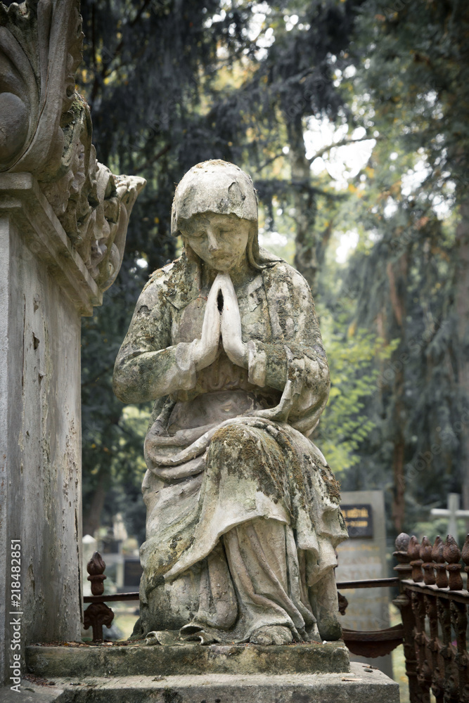 Obraz premium sad statue on cemetery