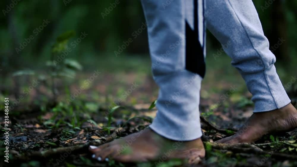 A person walks barefoot through a forest with painted toe nails. Close up view of the feet on the earth. A person walks barefoot through a forest with painted toe nails. Close up view of the feet on the earth.