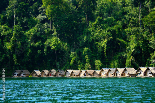 Fototapeta Naklejka Na Ścianę i Meble -  Landscape of Tropical floating bamboo bungalows and boats on the river near mountain background at Khao Sok National Park in Surat Thani southern of Thailand 