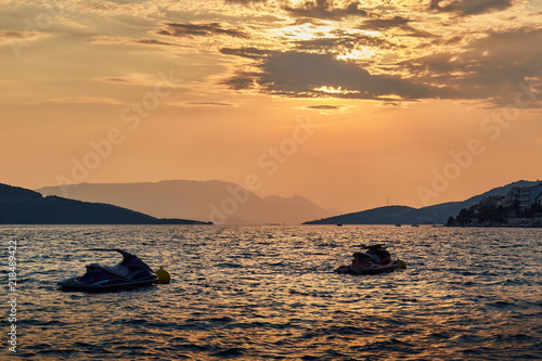 Two water scooters (jet ski) in ocean during the sunset