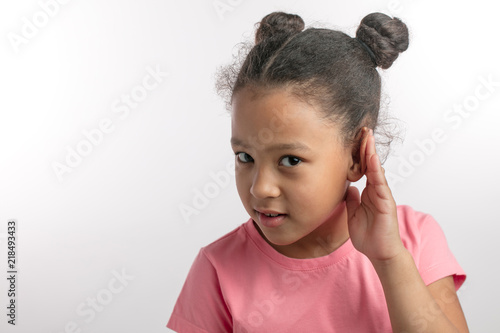 Bild auf Leinwand beautiful girl with dark hair in pink fashon dress is listening with her hand on an ear