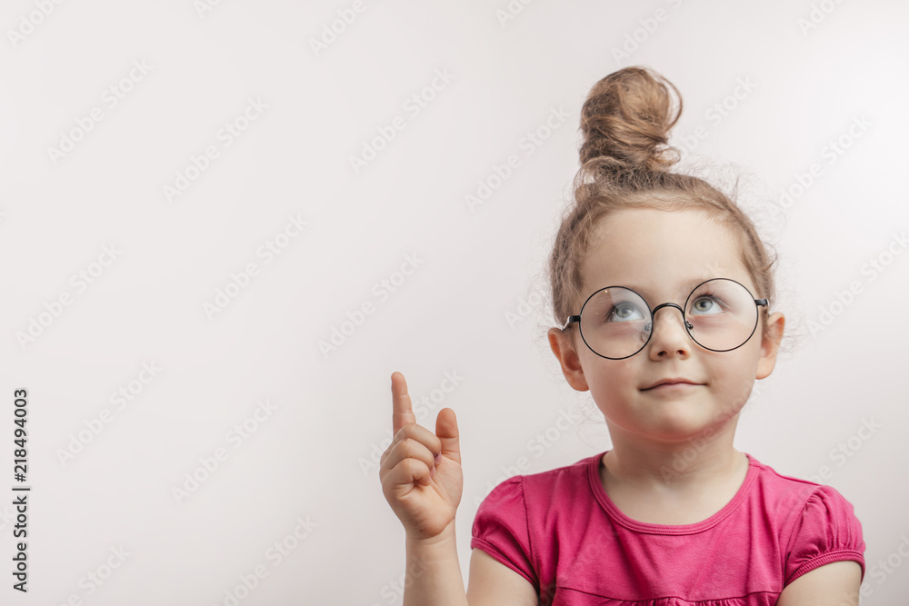 beautiful ginger kid in glasses with rised finger looking up. excellent idea, plan concept