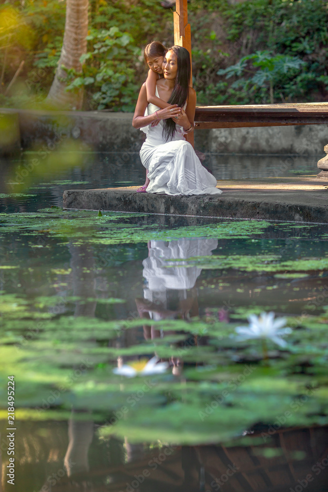 Mother with daughter spend time together in nature park with pond Mother with daughter spend time together in nature park with pond