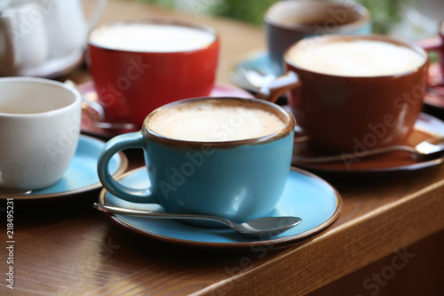 Cups of fresh aromatic coffee on wooden table