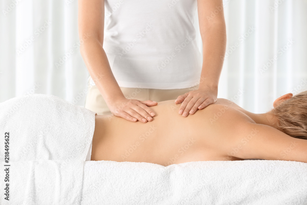 Fototapeta premium Relaxed woman receiving back massage in wellness center