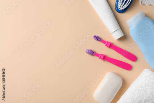 Flat lay composition with baby toothbrushes, toiletries and space for text on color background
