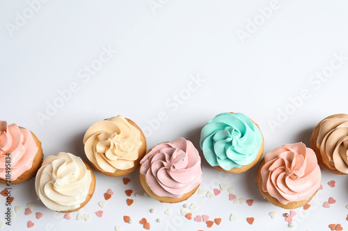 Flat lay composition with delicious birthday cupcakes and space for text on white background photo