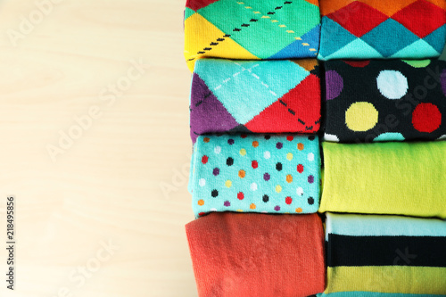 Rolled colorful socks on light background, top view