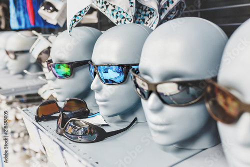 Many sport sunglasses on display in outdoors equipment shop