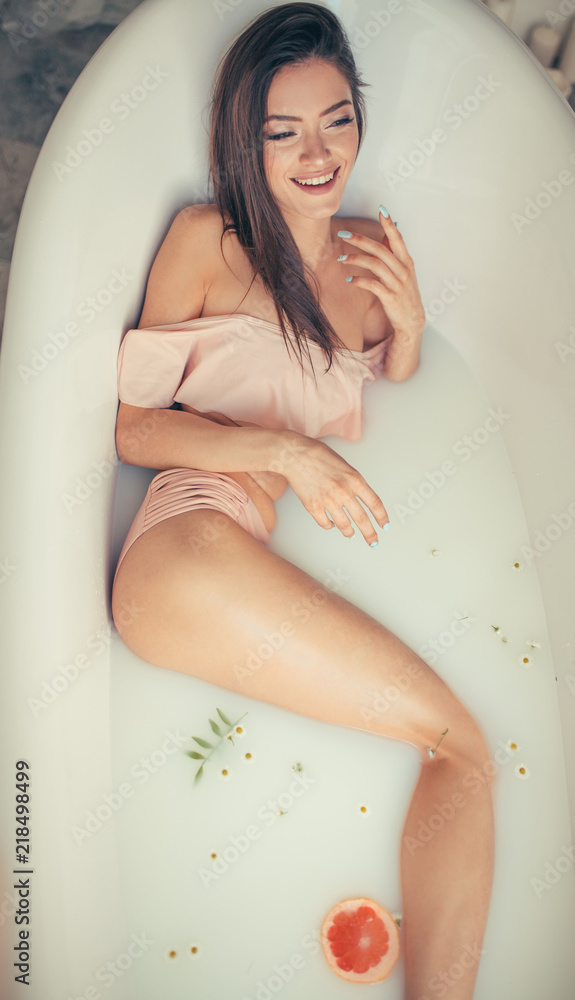 Specified Clinic Sports Spa and Bathroom time. Sexy woman in romantic lingerie lies in milk bath  decorated with slices of colourful citrus. Stock Photo | Adobe Stock