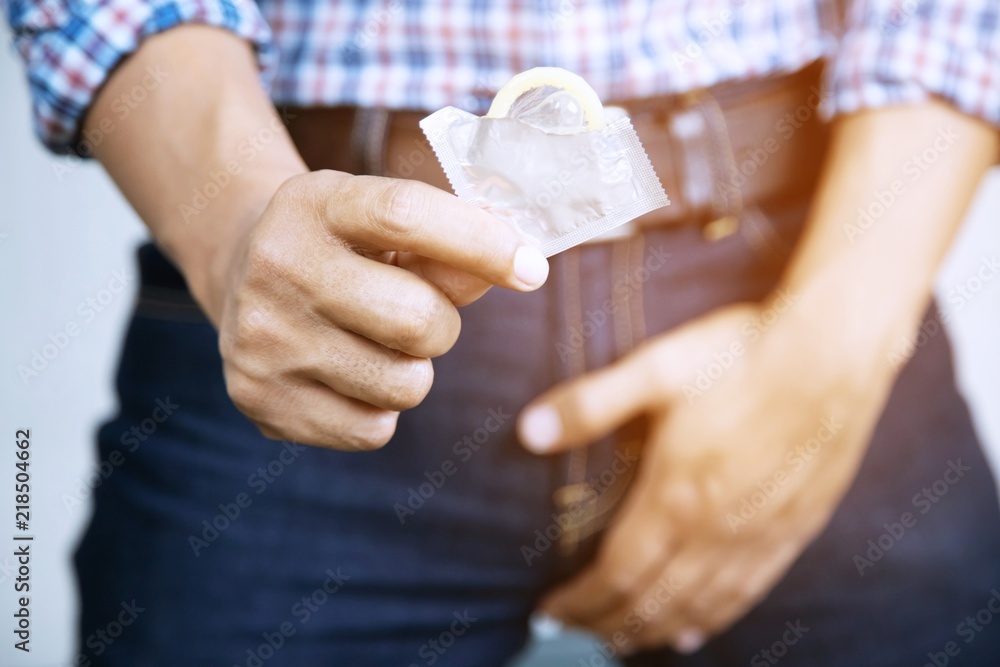 Stockfoto med beskrivningen Condom ready to use in young man hand