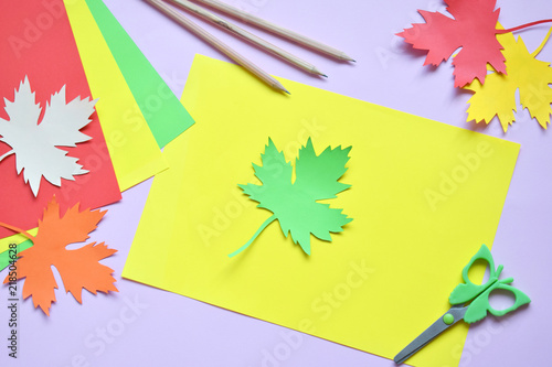 Making maple leaf from colored paper with your own hands for decoration of greeting card. Handmade crafts. Hello Autumn concept. Children s DIY. Copy space. Step 1. Circle the stencil.
