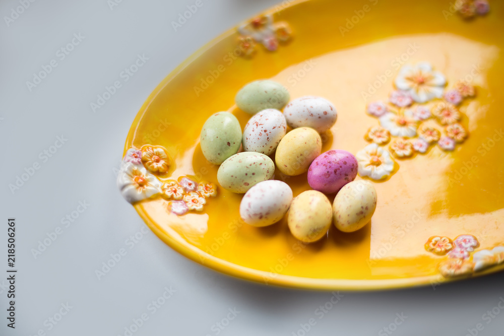 Colorful chocolate Eater eggs on a yellow plate