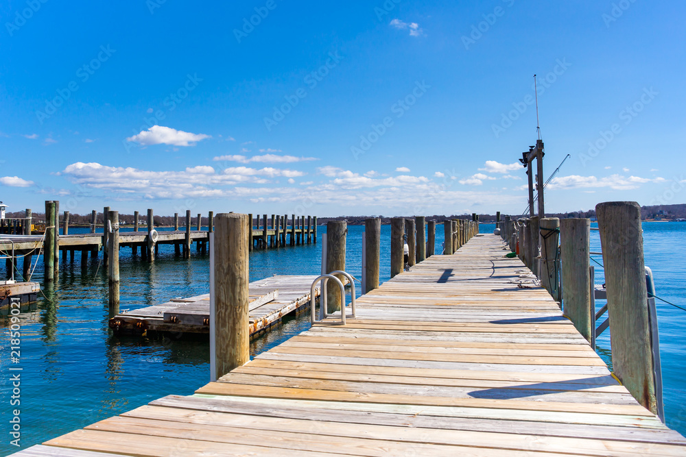 Wooden dock or pier by the lake in blue sky and white cloud.