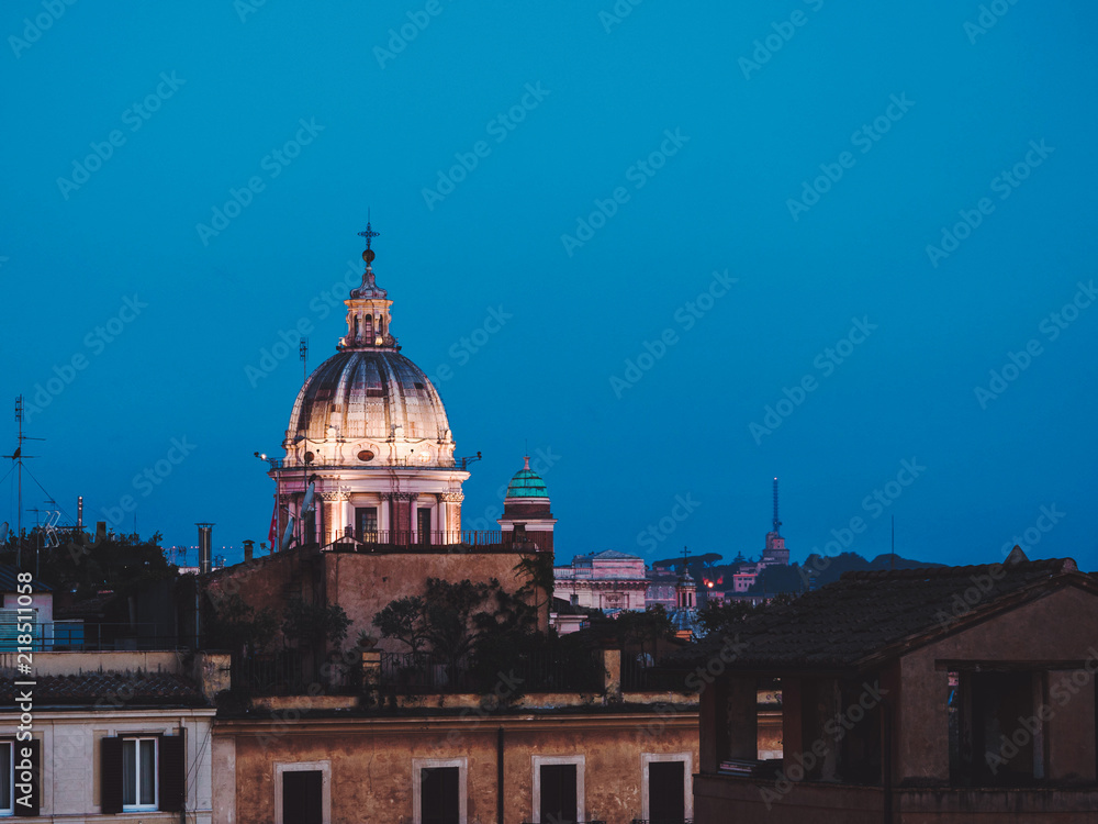 Beautiful night aerial view of Piazza Spagna - Rome, Italy. Dome of cathedral on blue sky background