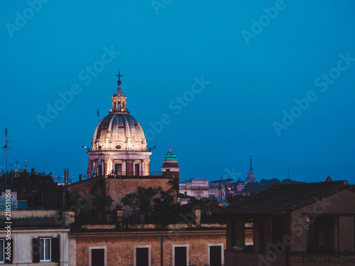 Beautiful night aerial view of Piazza Spagna - Rome, Italy. Dome of cathedral on blue sky background