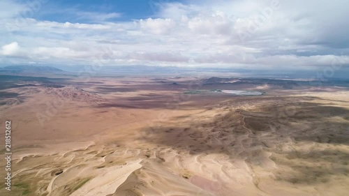 Panoramic view from above on a sandy desert with lakes. Flight over the barkhans in the desert. photo