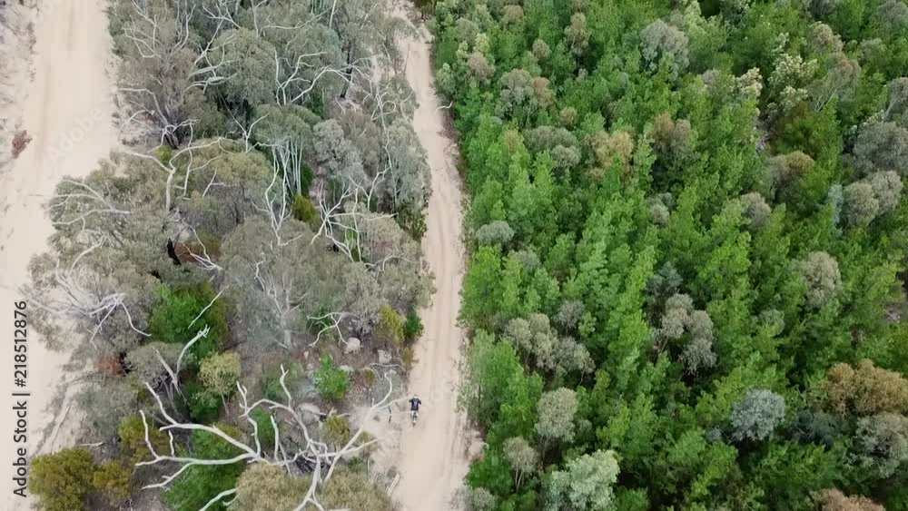 a tracking shot of two dirt bikers racing along a dirt road a tracking shot of two dirt bikers racing along a dirt road