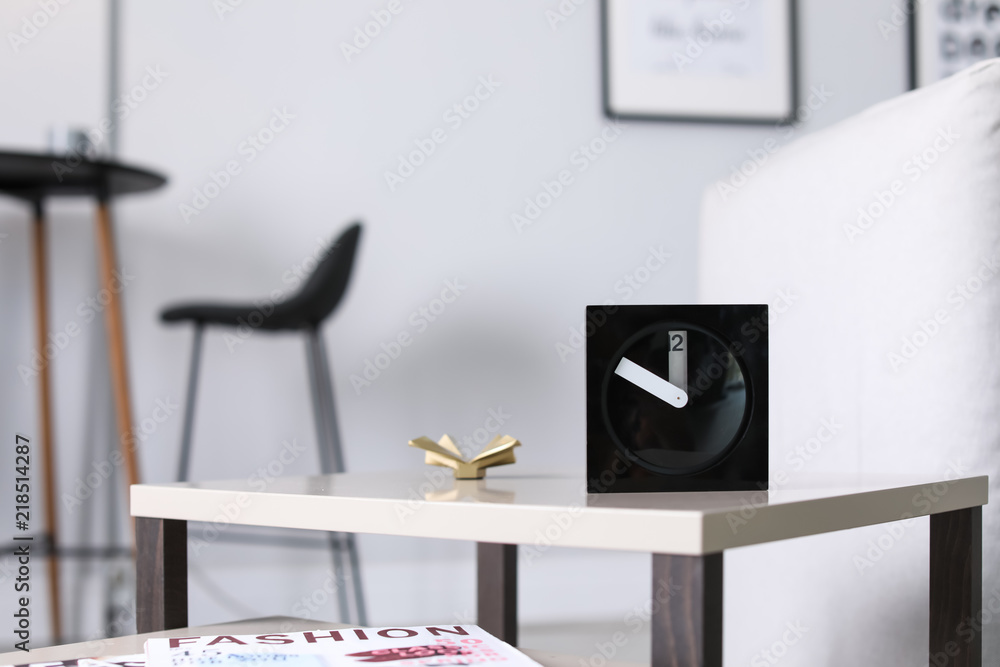 Obraz premium Analog alarm clock on table in living room. Time of day